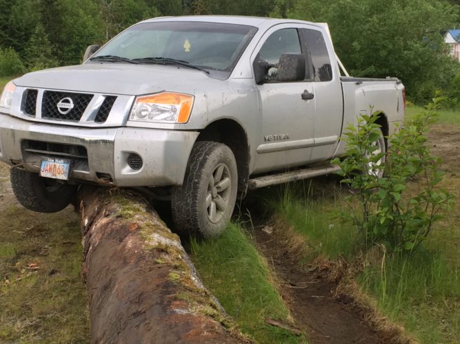 A man police say stole and damaged about eight vehicles in the past week left this truck high-centered on a large log. (Photo courtesy Wrangell Police Department)